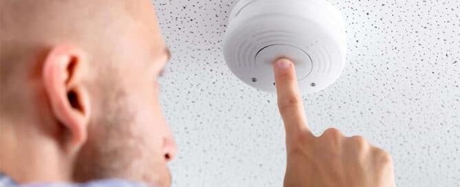 How Interconnected Smoke Alarms Can Help Save Your Life 1 man-testing-smoke-alarm